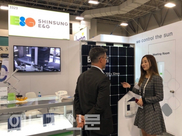 ▲ 신성이엔지 직원이 고객에게 양면형 태양광 모듈을 소개하고 있다.
