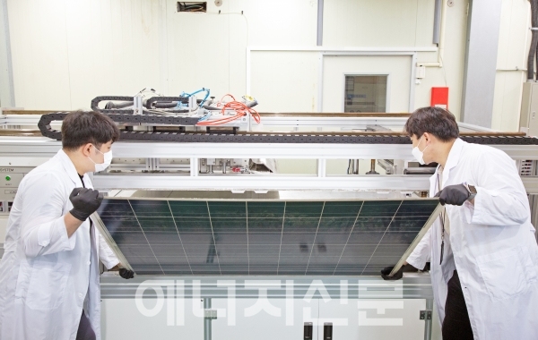 ▲ 연구원들이 유리를 분리·회수하기 위해 태양광 폐패널을 개발장치에 넣고 있다.