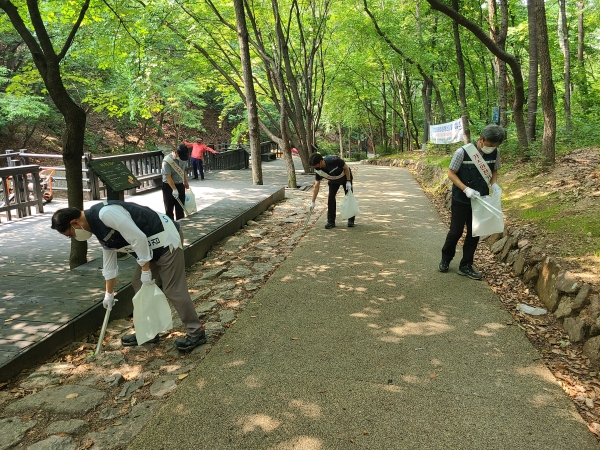 ▲ 대륜이엔에스 임직원들이 22일 수락산 등산로에서 환경정화활동을 벌이고 있다.
