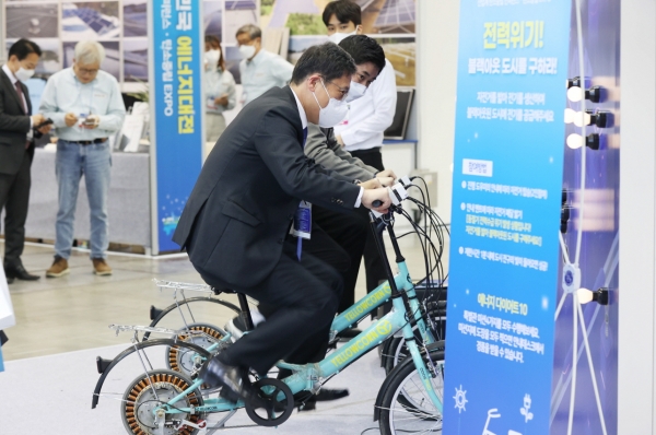 ▲ ‘2022 대한민국 에너지대전’ 체험 이벤트에서 이상훈 에너지공단 이사장이 자전거 페달을 밟으며 전기를 생산하고 있다.