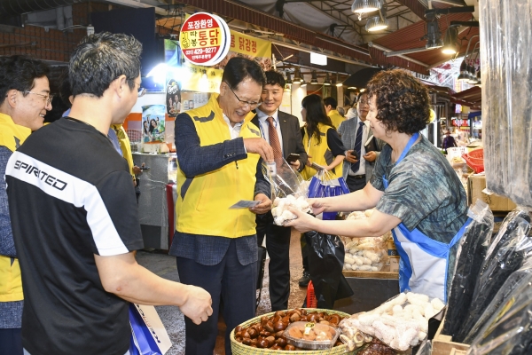 ▲ 호계종합시장에서 물품을 구입하고 있는 박지현 사장(왼쪽 세번째).