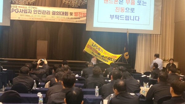 ▲ 구자열 경남LPG판매협회 회장이 LPG용기애 대한 검사비용 지원을 요청하는 플래카드를 사업자에게 들어 보이고 있다.
