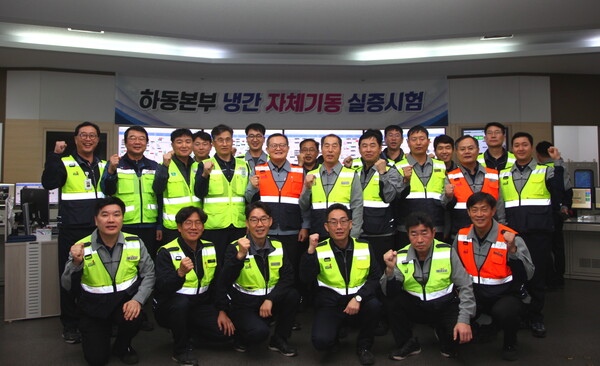 ▲윤상옥 하동빛드림본부장(두번째 줄 가운데 주황색 조끼)과 기술원들이 30일 하동본부 중앙제어실에서 자체기동 실증시험을 성공적으로 수행 후 기념촬영을 하고 있다.