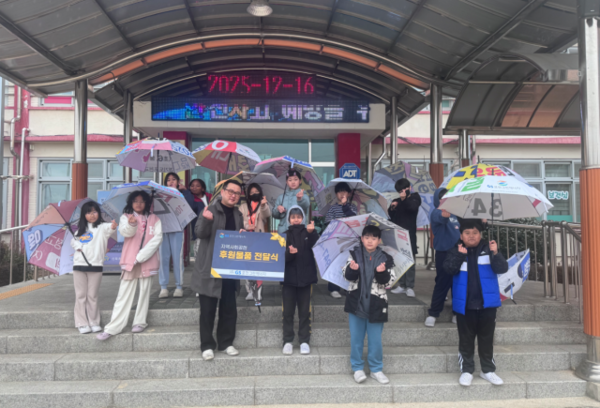 ▲ 신북초등학교 학생들이 폐현수막 새활용 우산을 쓰고 귀가 준비를 하고 있는 모습.