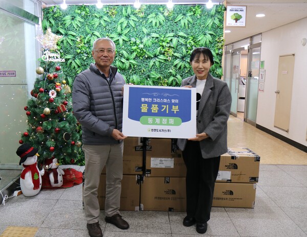 ▲ 인천도시가스 이상규 상무이사(좌측)가 파인트리홈 김주리 원장에게 동계점퍼를 전달한 뒤 기념촬영하고 있다.