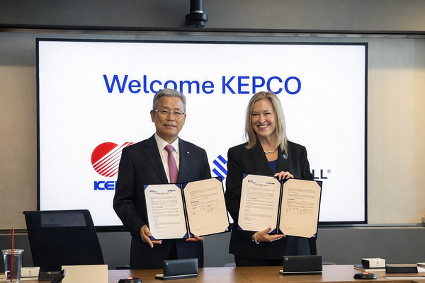 ▲김동철 한전 사장과 레슬리 듀크 번스앤맥도널 대표가 협약서와 함께 기념촬영을 하고 있다.