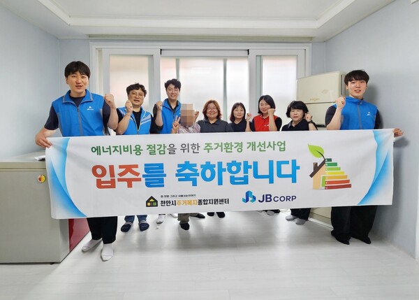 ▲ JB주식회사 임직원들이 주거취약계층 가정의 입주식에 참여, 기념촬영을 하고 있다. 