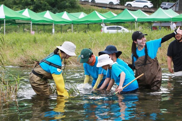 ▲ S-OIL 임직원과 가족 및 봉사활동 참가자들이 강원도 화천군 화천읍에서 황쏘가리 치어를 방류하고 있다.
