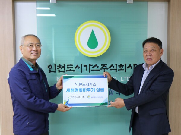 ▲이상규 인천도시가스 상무이사(왼쪽)가 박준용 새생명찾아주기운동본부장에게 성금을 전달한 뒤 기념촬영을 하고 있다.